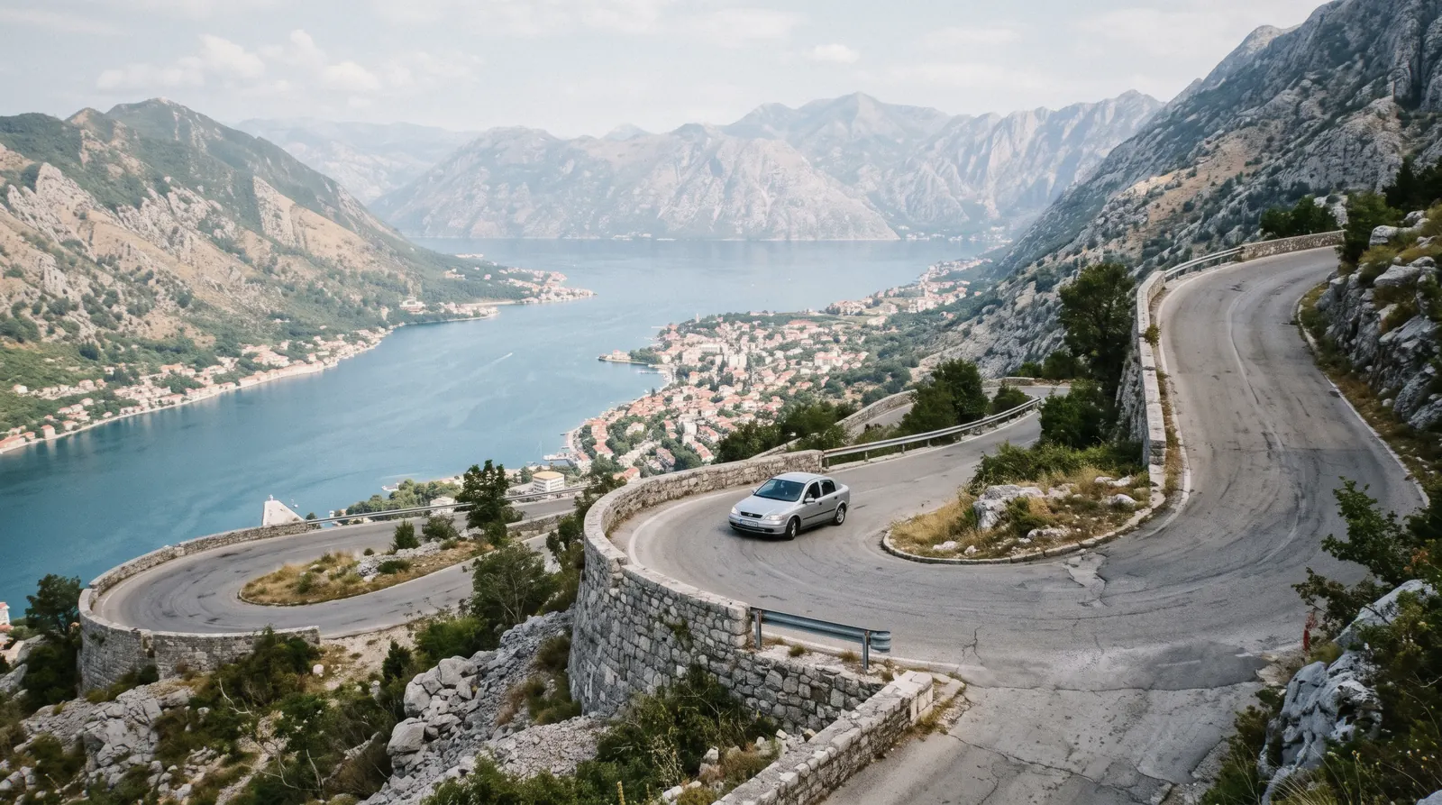 Narrow paved serpentine road climbing the slopes above the Bay of Kotor