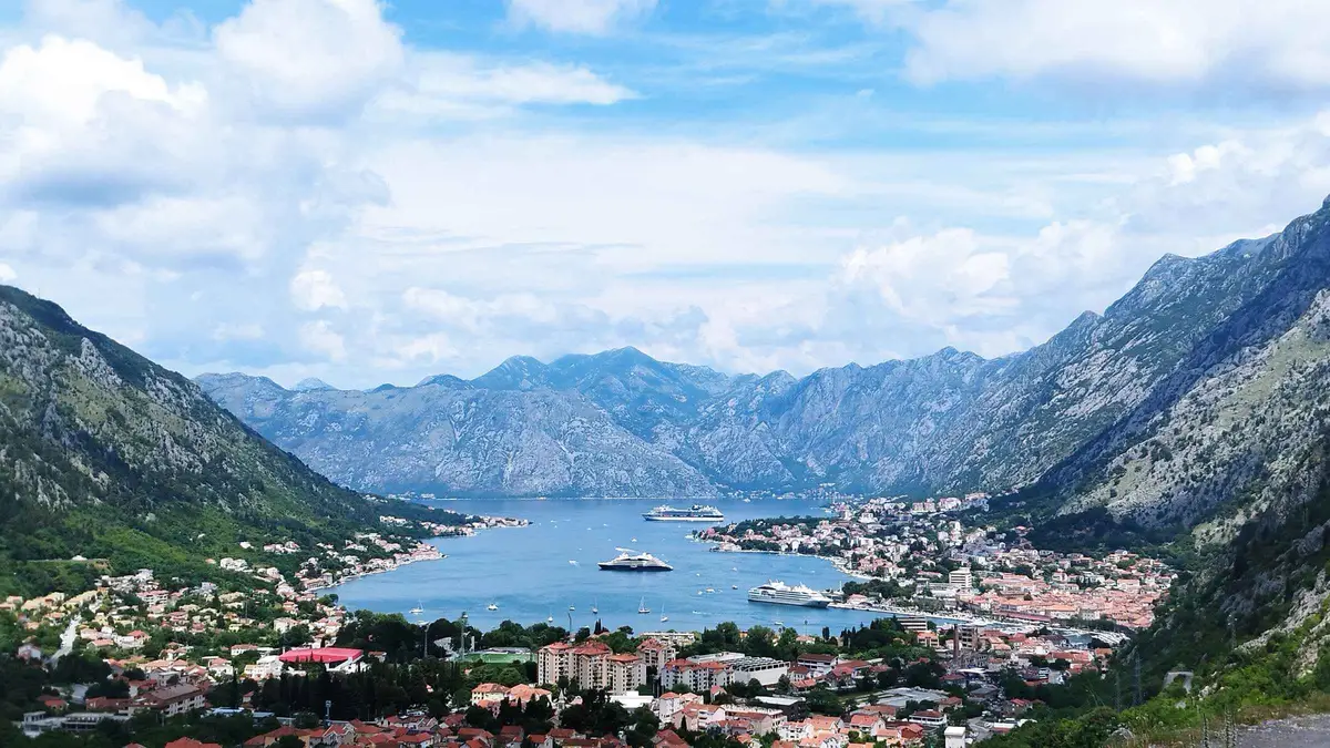 Cruise ship docked at the Port of Kotor beside the old town walls